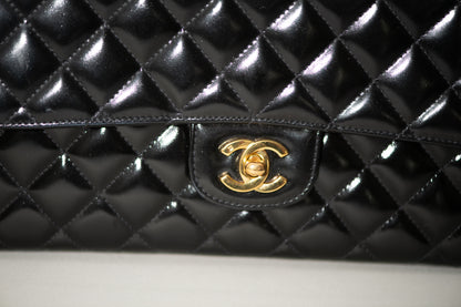 Authentic vintage Chanel Kelly Top Handle handbag in black quilted leather with 24K gold hardware