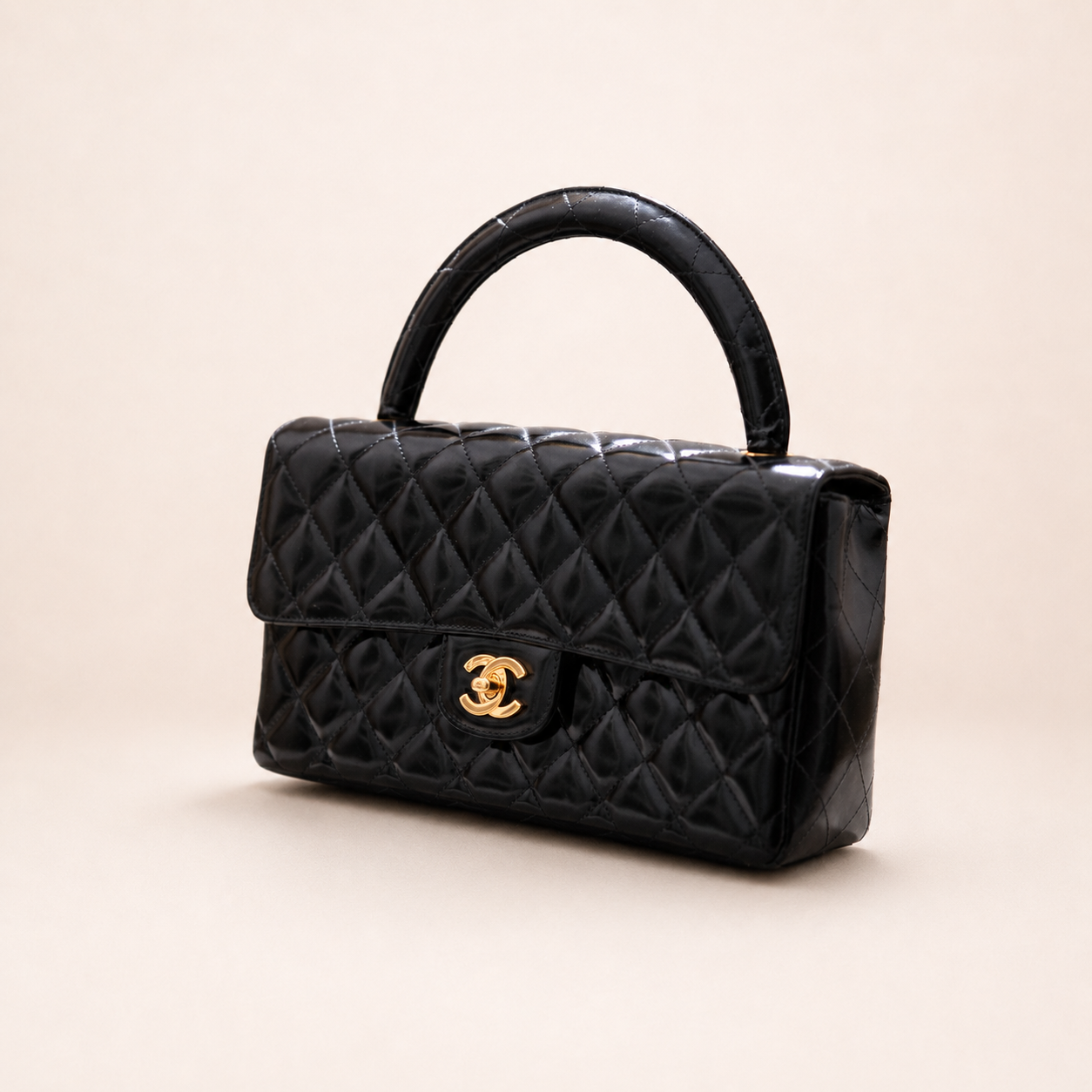 Authentic vintage Chanel Kelly Top Handle handbag in black quilted leather with 24K gold hardware