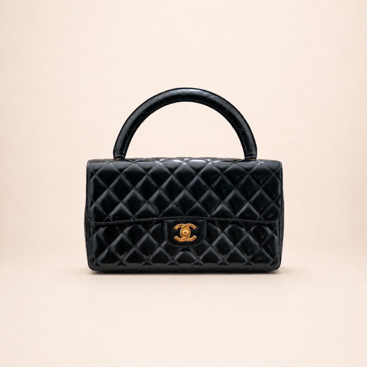 Authentic vintage Chanel Kelly Top Handle handbag in black quilted leather with 24K gold hardware