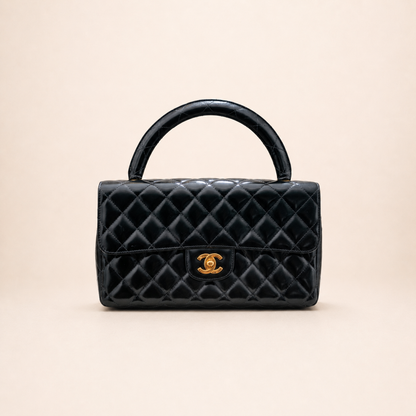 Authentic vintage Chanel Kelly Top Handle handbag in black quilted leather with 24K gold hardware